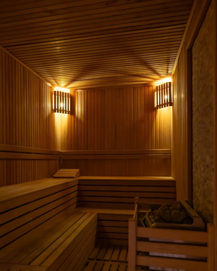 Experience relaxation in a serene sauna room with warm wooden interiors and calming lighting.